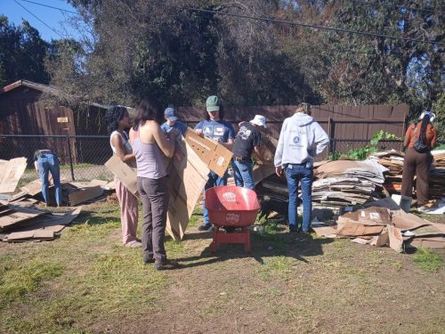 Group removing tape from cardboard