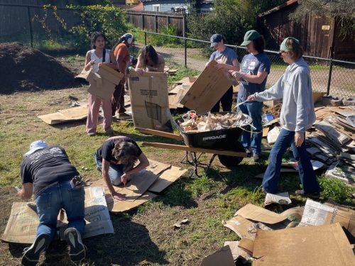 Volunteers removing tape from the cardboard